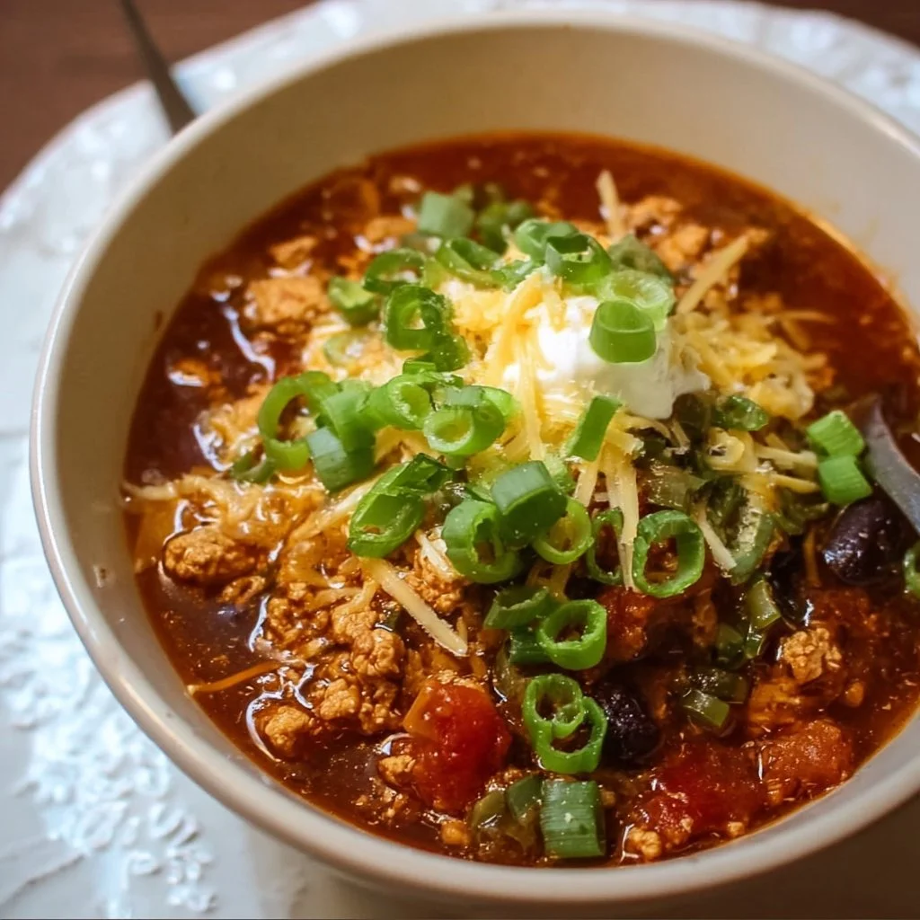 Delicious bowl of ground chicken chili topped with fresh herbs