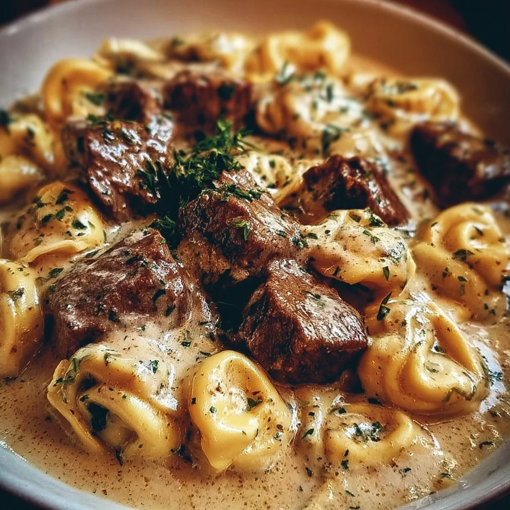 Cracked garlic steak tortellini in creamy sauce garnished with herbs