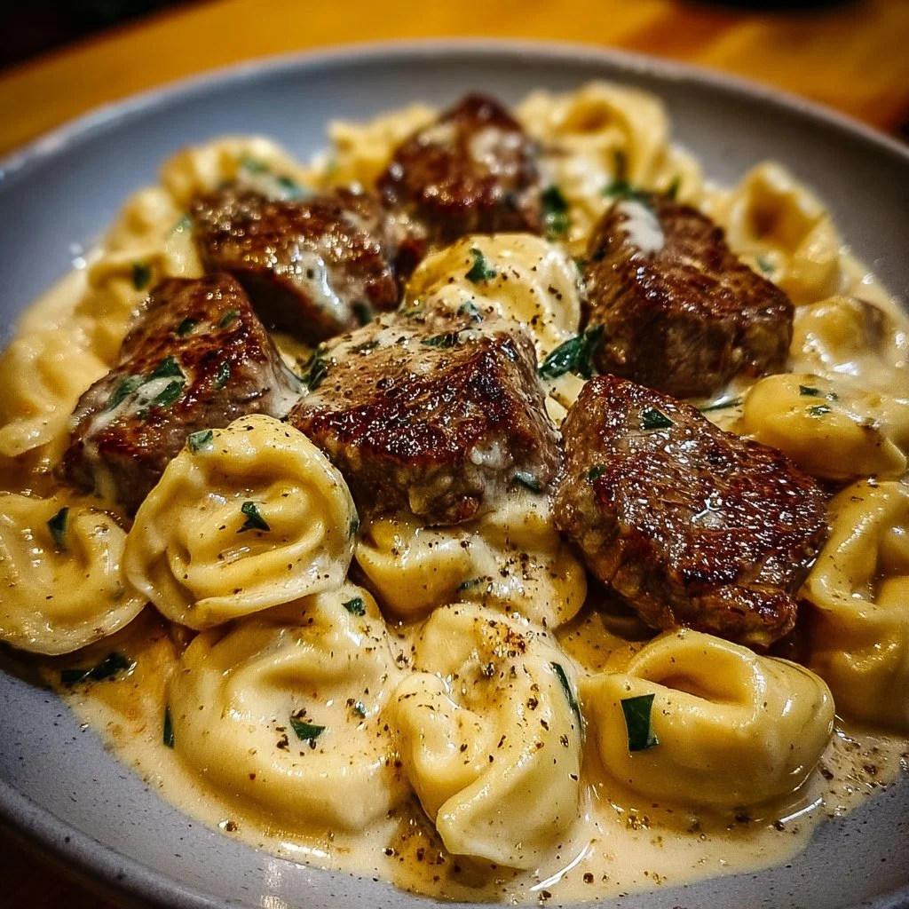 Cracked garlic steak tortellini in creamy sauce served on a plate.