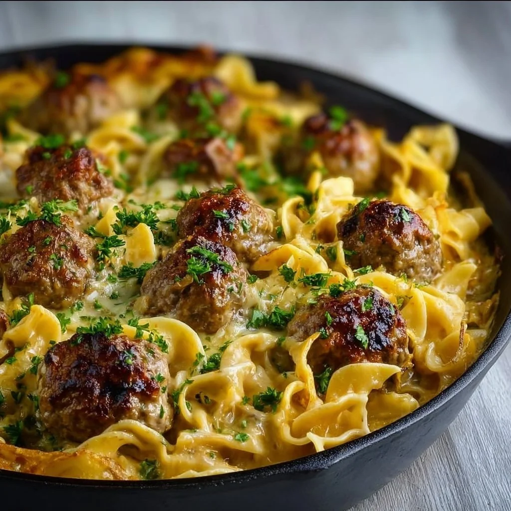 Baked Swedish meatball noodle casserole topped with cheese and herbs